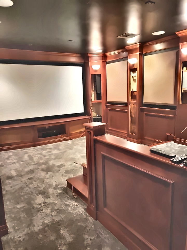 Custom home theater with wood paneling and built-in cabinetry
